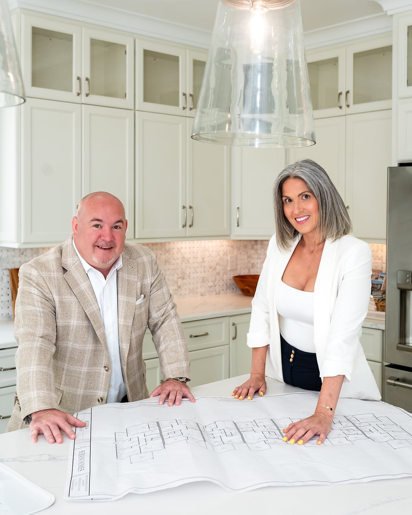Tim Duffy and Natalie Bisesto reviewing house plans at a kitchen island