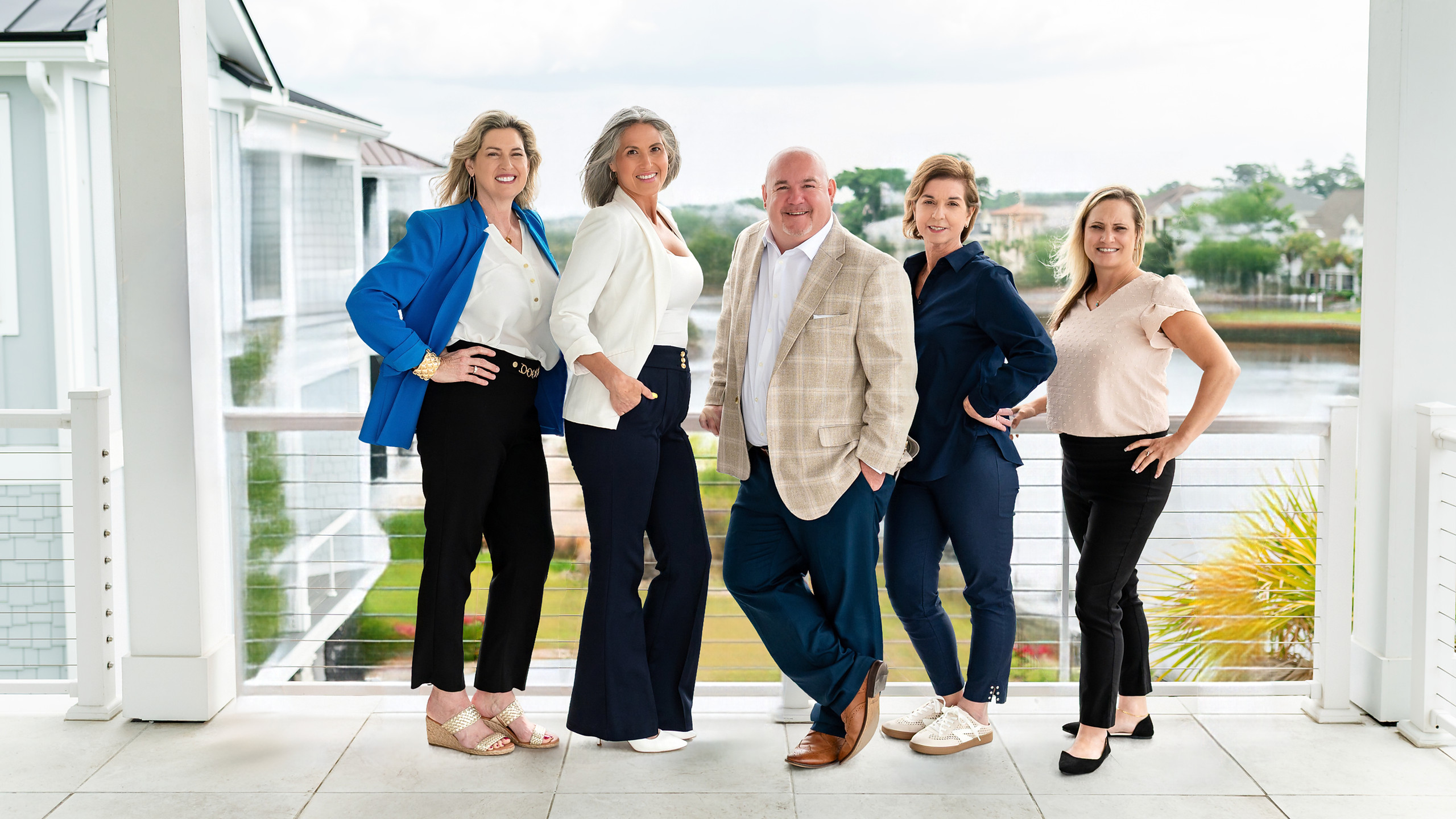 The five agents of the Duffy Bisesto Group on a waterfront balcony
